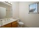 Well-lit bathroom featuring a wooden vanity, a large mirror, and a shower and tub combo at 15655 W Bethesda Ct, Surprise, AZ 85374