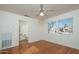 Bright bedroom featuring hardwood floors, a ceiling fan, and an adjoining bathroom at 15655 W Bethesda Ct, Surprise, AZ 85374