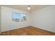 Bright bedroom featuring hardwood floors, a ceiling fan, and a window with vertical blinds at 15655 W Bethesda Ct, Surprise, AZ 85374