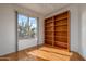 Bright bedroom with hardwood floors, a large window with a view, and built-in shelving at 15655 W Bethesda Ct, Surprise, AZ 85374