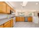 Bright kitchen with plentiful wood cabinetry, stainless appliances, and easy access to the living area at 15655 W Bethesda Ct, Surprise, AZ 85374