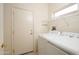 Bright laundry room featuring a washer, dryer, and shelving for storage at 15655 W Bethesda Ct, Surprise, AZ 85374