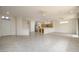 Bright, open-concept living area featuring neutral tile flooring and seamless flow into the kitchen at 15655 W Bethesda Ct, Surprise, AZ 85374