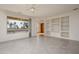 Bright living room with tile flooring, ceiling fan, built in shelving, and natural light at 15655 W Bethesda Ct, Surprise, AZ 85374