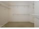 Spacious walk-in closet featuring carpet floors and multiple levels of white metal shelving at 15655 W Bethesda Ct, Surprise, AZ 85374