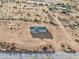 An aerial view of the home showing desert landscape and green roof at 164 S Oak Rd, Maricopa, AZ 85139
