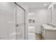 Modern bathroom with a glass-enclosed shower, double sink vanity, and wood-look floors at 164 S Oak Rd, Maricopa, AZ 85139