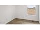 This vacant bedroom has hardwood floors, neutral walls and window at 164 S Oak Rd, Maricopa, AZ 85139