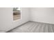 A vacant bedroom features light gray carpet and a bright, natural light from the window at 164 S Oak Rd, Maricopa, AZ 85139