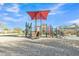 Community playground featuring a covered slide, climbing structures, and shaded seating area under a sunny blue sky at 18230 E El Viejo Desierto --, Gold Canyon, AZ 85118