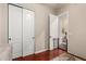 Bedroom with wood-look floors, double closet, white door, and view to bathroom at 1919 E Gary Way, Phoenix, AZ 85042