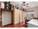 Bedroom features wood-look floors, overhead fan, natural light, and closet-storage system with rustic barn doors at 1919 E Gary Way, Phoenix, AZ 85042
