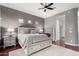 A primary bedroom with a view to an attached bathroom features a ceiling fan and wood floors at 1919 E Gary Way, Phoenix, AZ 85042
