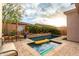 Backyard pool oasis features a spa, travertine stone, and lush landscaping at 1919 E Gary Way, Phoenix, AZ 85042