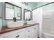 Bathroom featuring dual vessel sinks, wood countertop, and a tub with shower at 1942 E Connemara Dr, San Tan Valley, AZ 85140