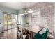 This lovely dining area with brick accent wall, stylish lighting, and backyard views is perfect for entertaining at 1942 E Connemara Dr, San Tan Valley, AZ 85140