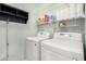Efficient laundry room featuring white washer and dryer units with overhead shelving at 1942 E Connemara Dr, San Tan Valley, AZ 85140