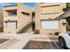 Multi-story condo building showcasing its tan stucco facade, staircase access, and covered parking area at 2228 N 52Nd St # 245, Phoenix, AZ 85008