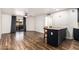 Open concept living room with wood floors, a balcony, and a kitchen island with bar stool seating at 2228 N 52Nd St # 245, Phoenix, AZ 85008