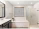 Bright bathroom boasting a soaking tub, a glass-enclosed shower, and a large vanity mirror at 22538 E Tierra Grande --, Queen Creek, AZ 85142