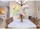 Charming dining room with seating for six, decorative chandelier, and colorful cactus artwork at 22565 W La Pasada Blvd, Buckeye, AZ 85326