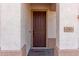 Close-up of a beautiful wooden front door with decorative accents and visible house number at 22565 W La Pasada Blvd, Buckeye, AZ 85326