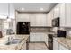Modern kitchen with granite countertops, black appliances, and ample cabinet space at 22565 W La Pasada Blvd, Buckeye, AZ 85326