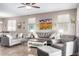 Bright living room featuring two sofas, an armchair, a ceiling fan, and wall art at 22565 W La Pasada Blvd, Buckeye, AZ 85326