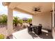 A covered patio with seating and a ceiling fan overlooks the desert landscaping at 22565 W La Pasada Blvd, Buckeye, AZ 85326
