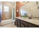 Bathroom featuring double sinks with granite countertops and a shower over bathtub at 2320 E Allen St, Phoenix, AZ 85042
