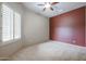 Empty bedroom features neutral carpet, shutters, and a ceiling fan at 2320 E Allen St, Phoenix, AZ 85042