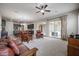 Open-concept living room flows to the kitchen with wood furniture, a ceiling fan, and an open patio view at 2320 E Allen St, Phoenix, AZ 85042
