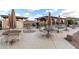 Outdoor patio with multiple tables and umbrellas providing shade for community gatherings at 2442 E University Dr # 6, Mesa, AZ 85213