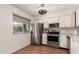 Bright kitchen featuring stainless steel appliances, white cabinetry, and a window with blinds at 2442 E University Dr # 6, Mesa, AZ 85213