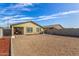 Back exterior featuring a covered patio, xeriscaped landscaping, and a concrete block wall at 24531 W Cocopah St, Buckeye, AZ 85326