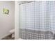 Clean bathroom with a shower featuring a patterned curtain and neutral tile at 24531 W Cocopah St, Buckeye, AZ 85326