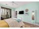 Airy bedroom with light green walls, ceiling fan, balcony access, TV, and comfortable furnishings at 2511 W Queen Creek Rd # 163, Chandler, AZ 85248