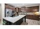 Kitchen featuring stainless appliances, granite countertops, dark wood cabinets and an island with a sink and gold fixtures at 2693 E Lodgepole Dr, Gilbert, AZ 85298