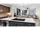 Kitchen island showcasing a black sink, granite countertops, and black cabinetry with views to the living room at 2693 E Lodgepole Dr, Gilbert, AZ 85298