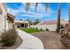 Backyard featuring artificial turf, a covered patio, desert landscaping, and a concrete walkway at 2701 E Lockwood St, Mesa, AZ 85213
