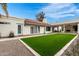 Beautiful backyard with lush artificial grass, a covered patio, and a well-maintained exterior at 2701 E Lockwood St, Mesa, AZ 85213