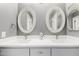 Elegant bathroom featuring double sinks, framed oval mirrors, and modern faucets at 2701 E Lockwood St, Mesa, AZ 85213