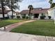 Charming single-story home featuring a lush lawn, red-tiled roof, and a welcoming brick pathway to the entrance at 2701 E Lockwood St, Mesa, AZ 85213