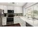 Stylish kitchen with stainless appliances, a farmhouse sink, and white cabinets with plenty of countertop space at 2701 E Lockwood St, Mesa, AZ 85213