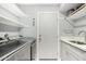 Well-equipped laundry room with stainless steel washer and dryer, sink, and storage at 2701 E Lockwood St, Mesa, AZ 85213