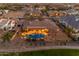 Aerial view of a desert home's backyard pool with lights and covered patio at twilight at 2998 E Waterman Way, Gilbert, AZ 85297