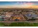 Sunset aerial view of backyard with pool and putting green in a desert community at 2998 E Waterman Way, Gilbert, AZ 85297