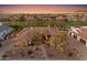 Aerial view of desert home with stone accents, lush landscape and green common space nearby at 2998 E Waterman Way, Gilbert, AZ 85297