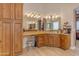 Bathroom with a large mirror, natural wood cabinetry, and a makeup area with a chair at 2998 E Waterman Way, Gilbert, AZ 85297