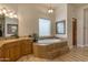 Main bathroom with soaking tub and vanity with granite countertop at 2998 E Waterman Way, Gilbert, AZ 85297